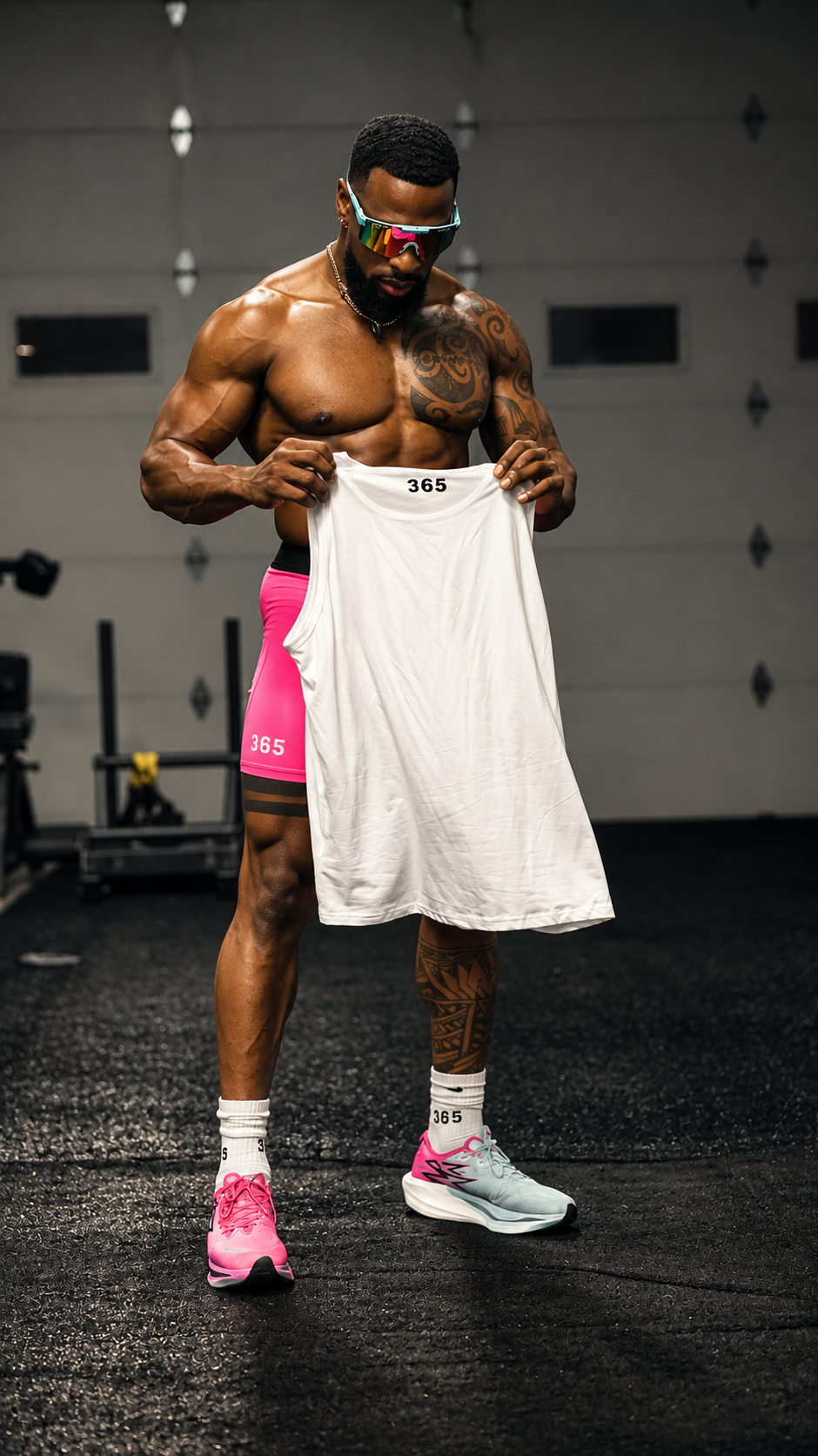 Athlete wearing pink 365 fitted shorts and presenting a white 365 tank top